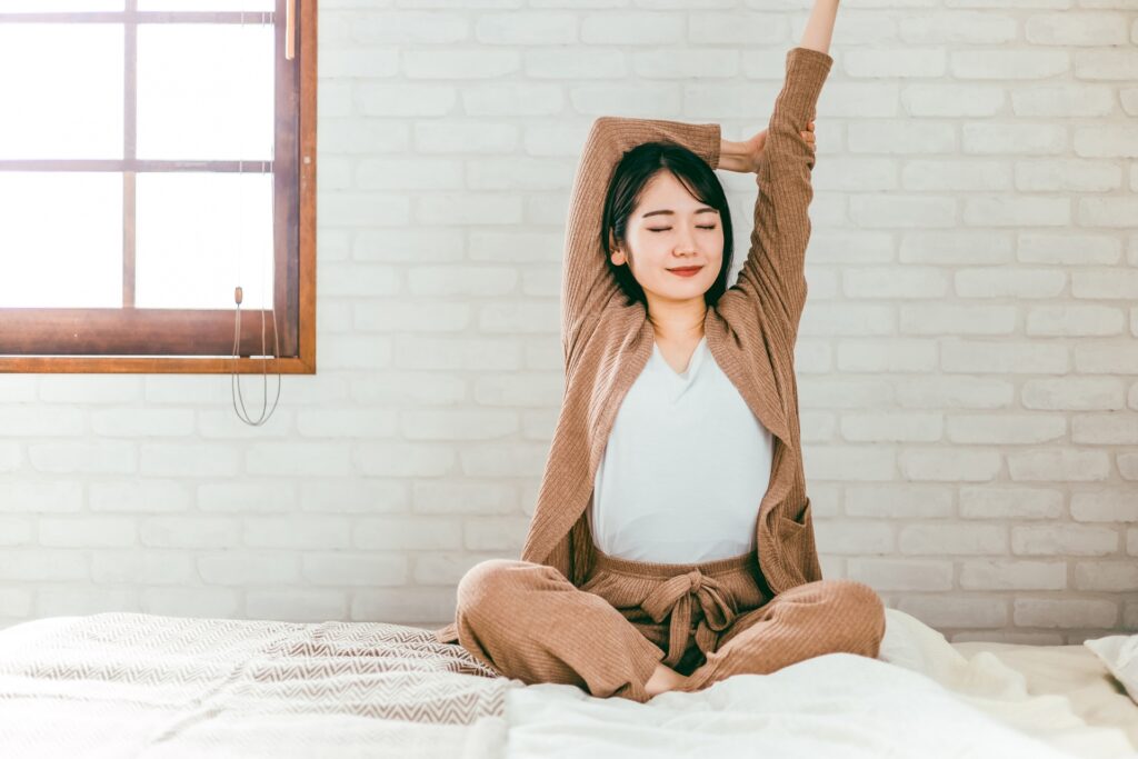 寝床でストレッチする女性